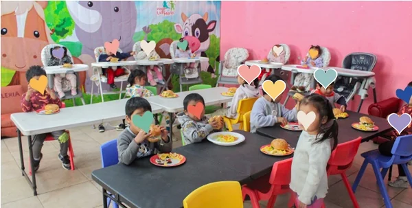 Niñas y niños almorzando juntos en el comedor del Hogar