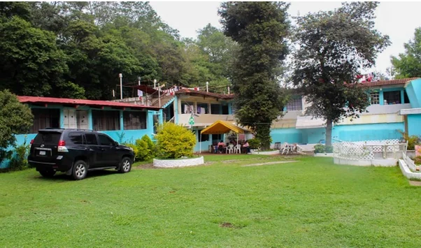 La casa del Hogar rodeada de jardín y árboles